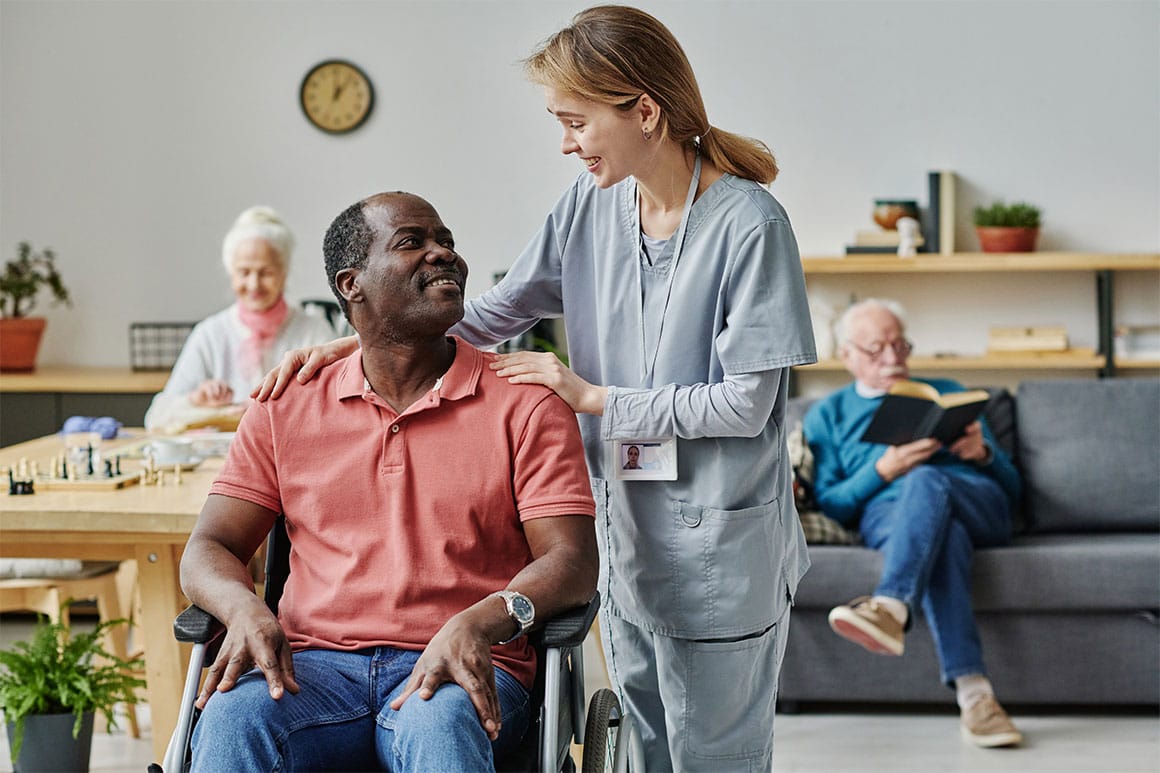 A nursing home caregiver with an elderly man.