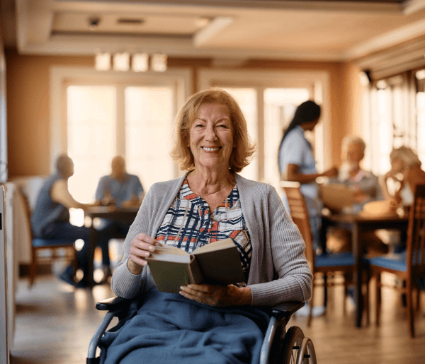 An elderly woman in a nursing home smiling.